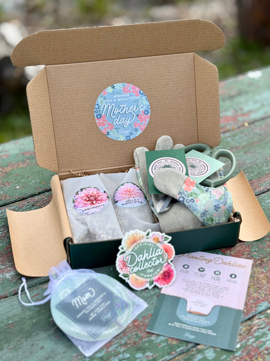 Open cardboard box containing Mother's Day-themed items on a wooden surface